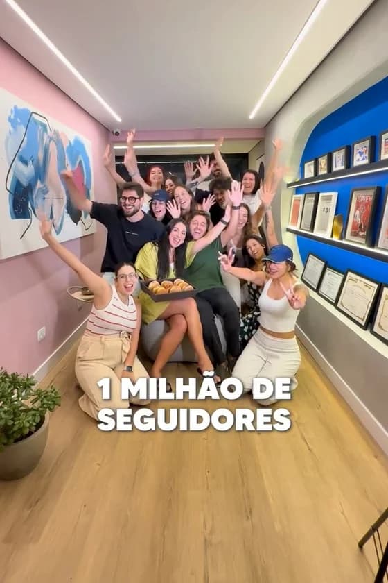 Time do Grupo Luz reunido no escritório, de braços erguidos e comemorando, com a legenda "1 milhão de seguidores".